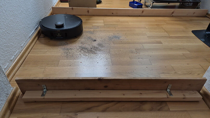 Der MOVA Z60 Ultra Roller beim Saugtest auf Hartboden mit Haferflocken und Linsen.